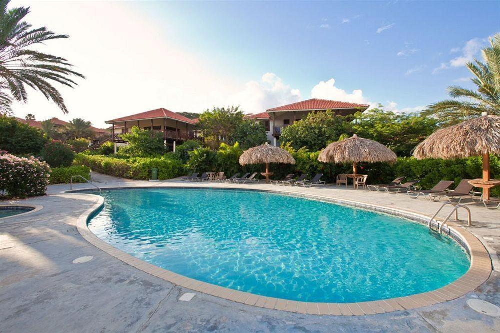 a swimming pool in front of a resort at Villa at the Beach, Blue Bay Golf & Beach Resort in Blue Bay