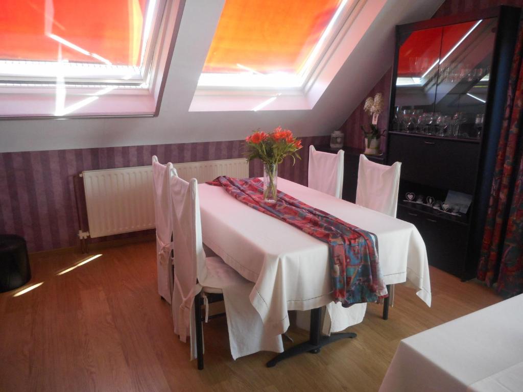 a dining room with a table with flowers on it at B&B Fresco in Ieper