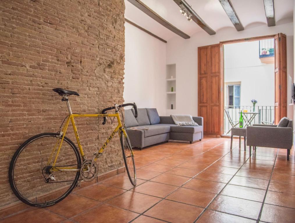 バレンシアにあるAmbrosio Flats Valencia - El Carmenの煉瓦の壁に黄色の自転車が置かれたリビングルーム