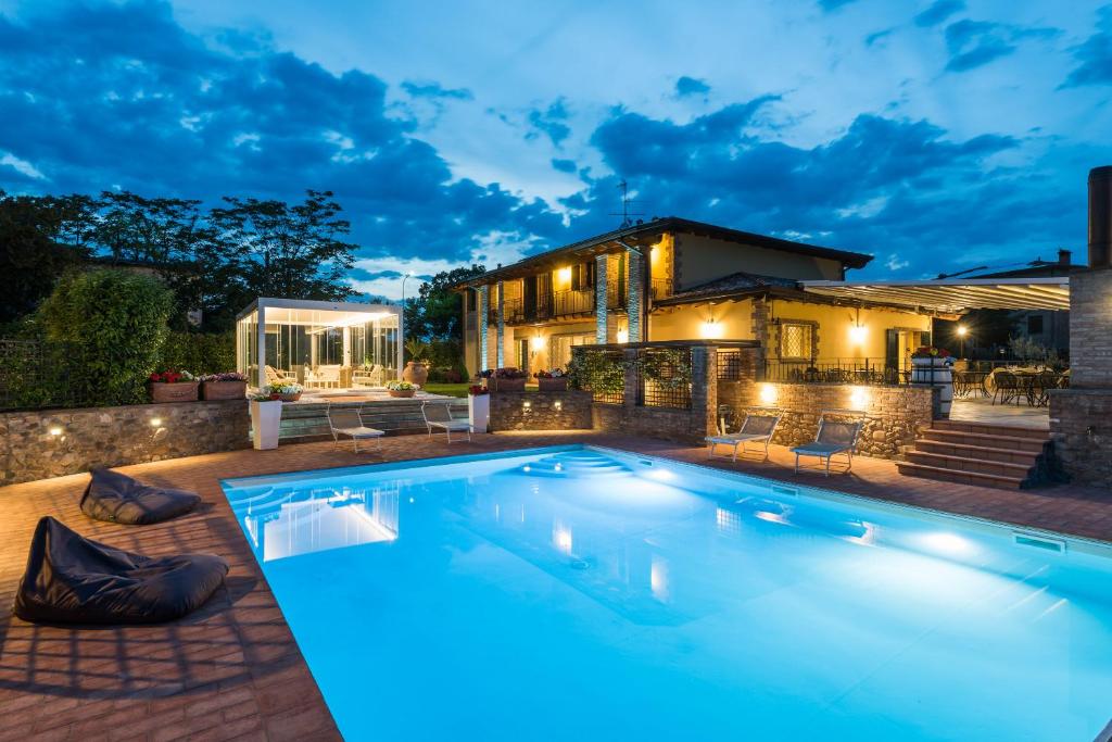 a swimming pool in front of a house at night at Agriturismo Acetaia Sereni in Marano sul Panaro