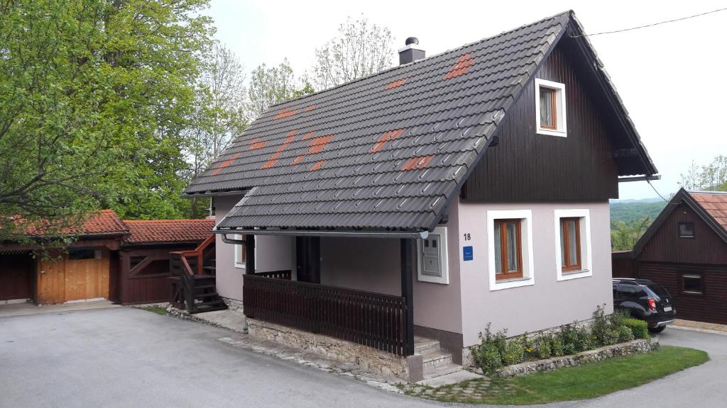 una pequeña casa con techo negro en Guesthouse Andrea en Poljanak