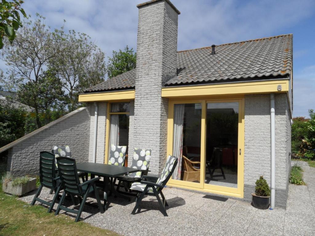 a table and chairs in front of a house at Vakantiehuizen Hollandse Kust in Julianadorp