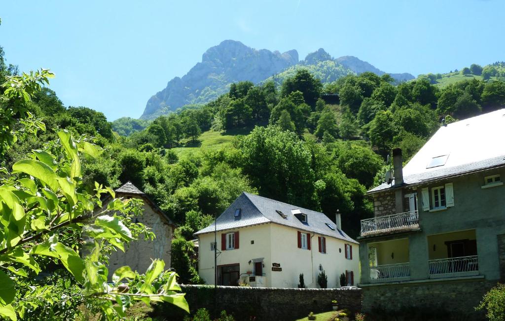 una casa en un pueblo con montañas en el fondo en Maison Bergoun, en Borce
