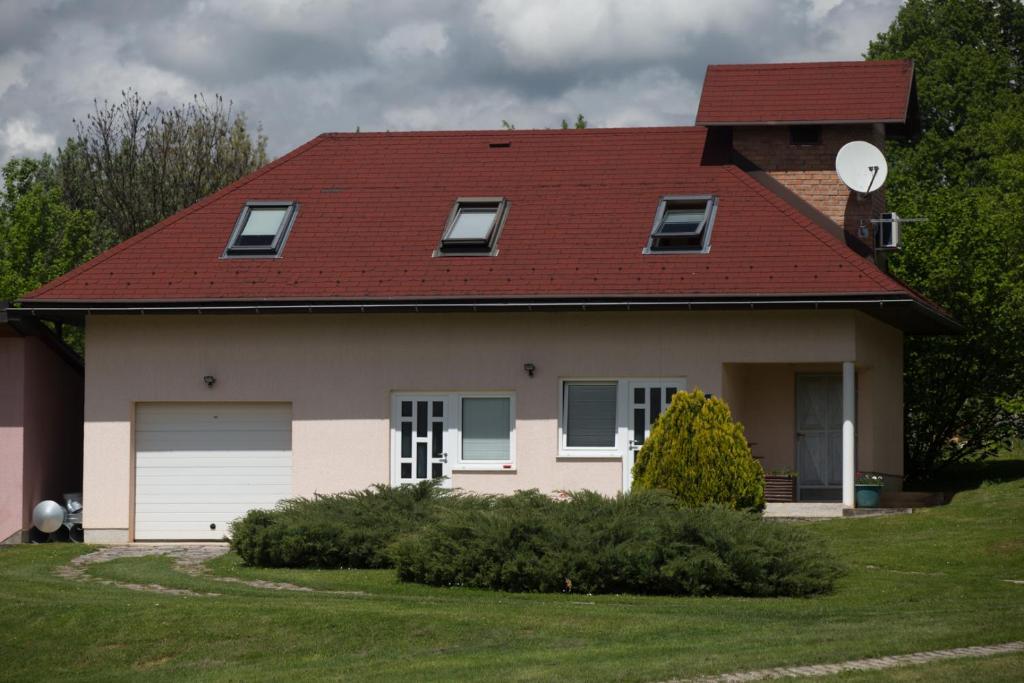 a house with a red roof and a garage at Apartment Oreskovic in Otočac