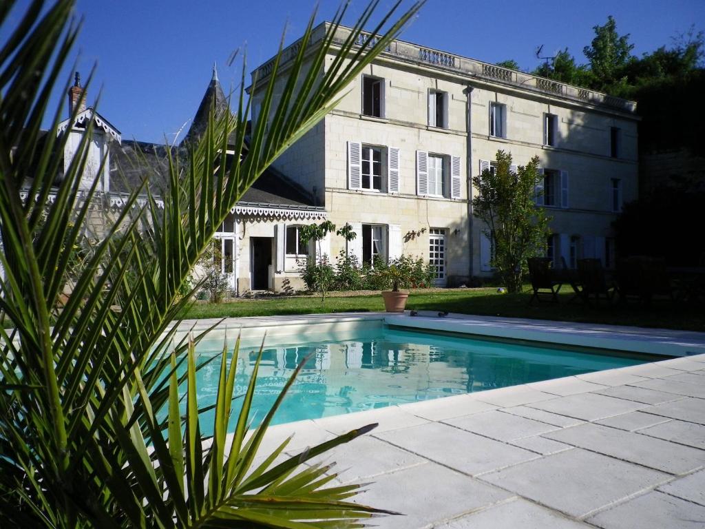 a house with a swimming pool in front of a building at Chambre D' Hôtes La Lucasserie in Saumur