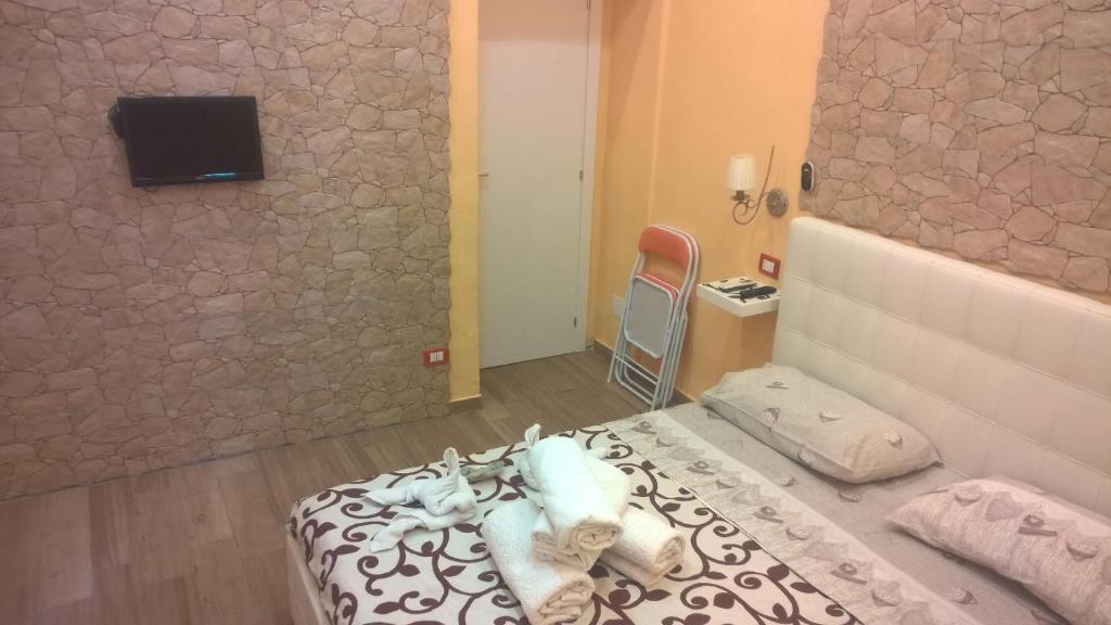 ナポリにあるB&B Simyのベッドルーム1室(ベッド1台、壁にテレビ付)