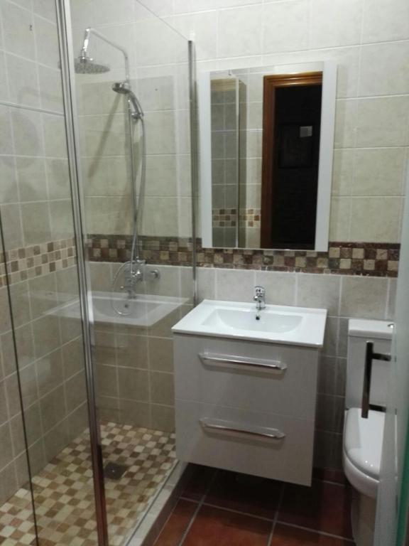 a bathroom with a sink and a shower and a toilet at Villa Rosal- Solo familias y parejas in Conil de la Frontera