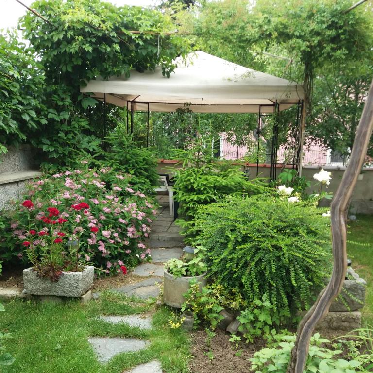 a garden with a gazebo and some flowers at Stai Za Gosti Venera in Hisarya