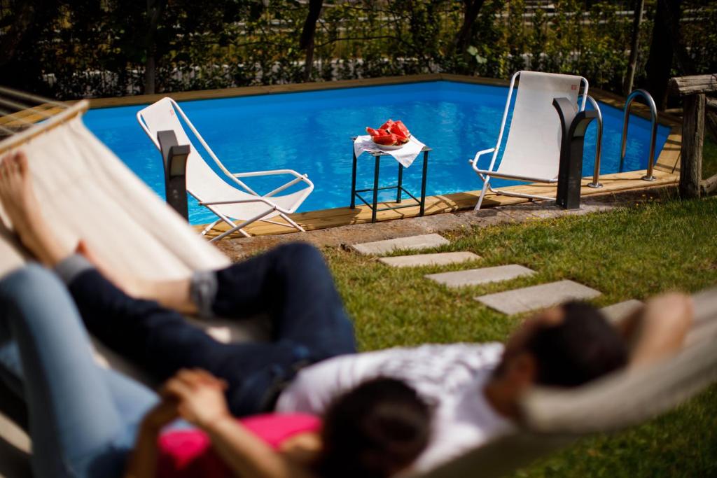 un grupo de personas tumbadas en sillas junto a una piscina en Villa Eugenia, en Sant'Agnello