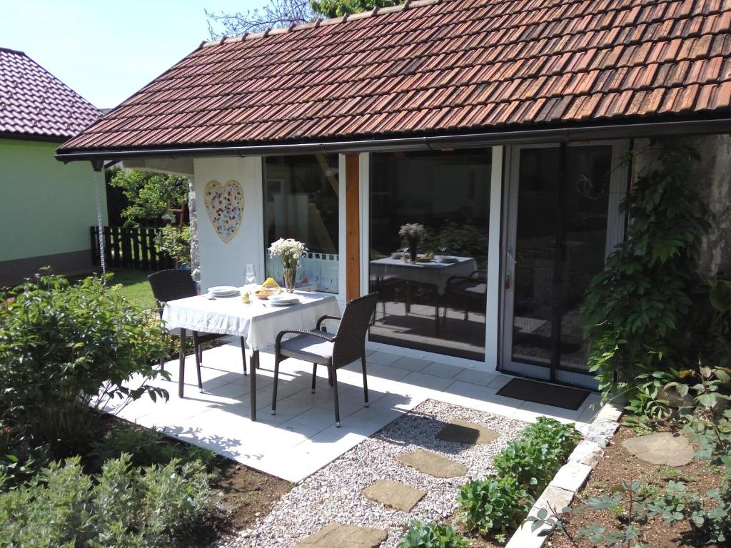 eine Terrasse mit einem Tisch und Stühlen darauf in der Unterkunft Tiny house with a big heart in Postojna