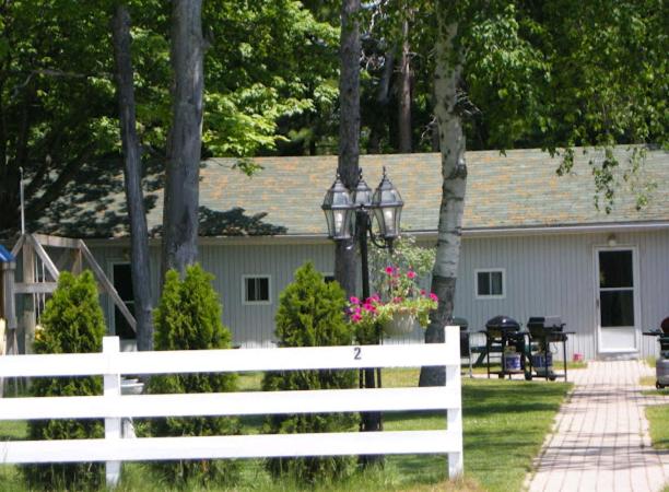 a white fence in front of a house at Birch Haven by the Beach in Wasaga Beach