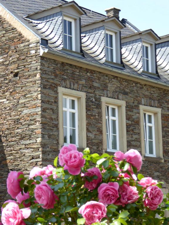 a house with pink roses in front of it at Winzerhaus Andel in Bernkastel-Kues