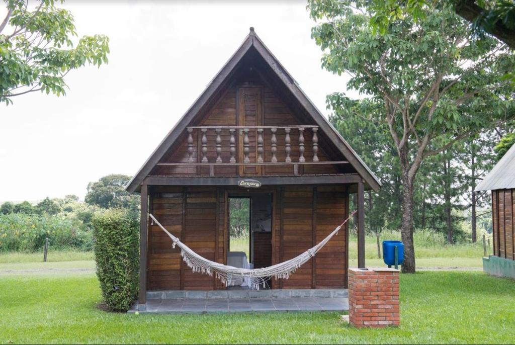 uma pequena casa com uma rede na relva em Pousada Corujas em Itu