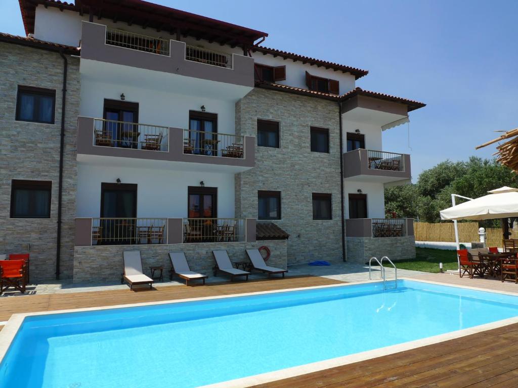 une villa avec une piscine en face d'un bâtiment dans l'établissement Apartment & Studios Haido, à Vourvourou