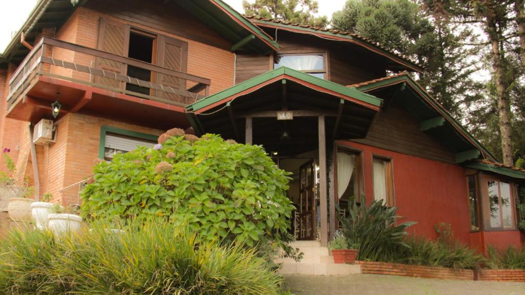 a house with a balcony on top of it at Pousada Pinha Pinhão in Gramado