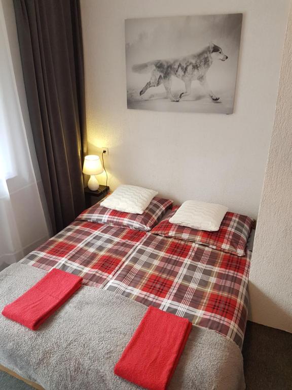 a bedroom with a bed with red towels on it at Willa Grafit in Karpacz