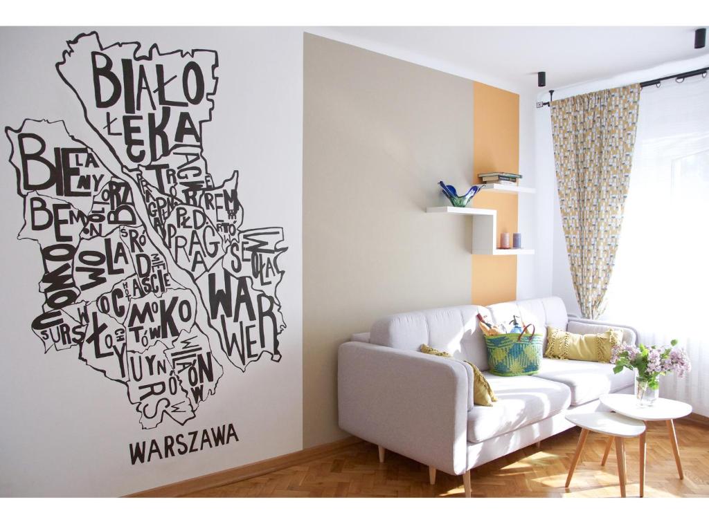 ワルシャワにあるNowolipie Warsaw Apartmentの白いソファと壁のあるリビングルーム