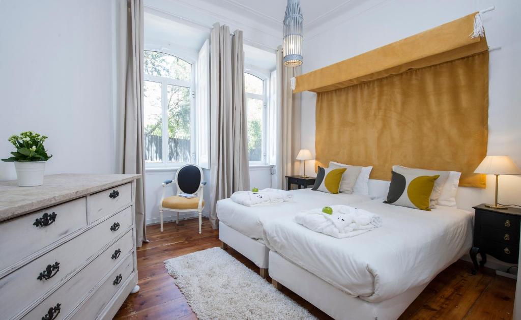 a bedroom with two beds and a dresser at Lisbon Dreams Estrela Suites in Lisbon