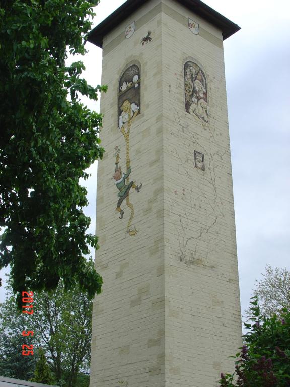 una torre del reloj con pinturas al costado. en Am Märchenturm, en Blankenburg