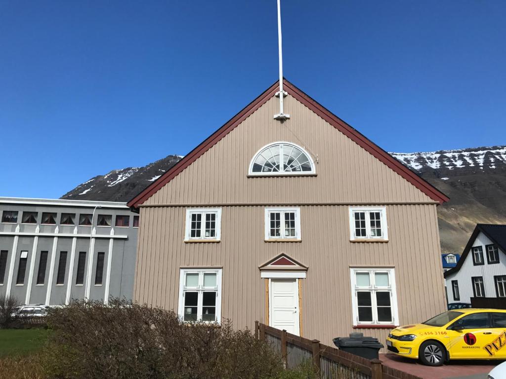 a church with a yellow car parked in front of it at Tangs in Ísafjörður
