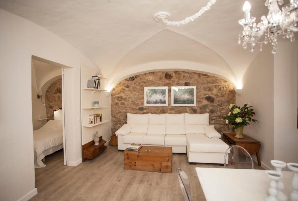 Una sala de estar con un sofá blanco y un dormitorio. en Apartamento Torre Redonda - AT-CC-00355, en Cáceres