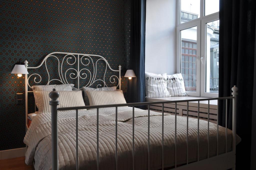 Schlafzimmer mit einem Bett und einem Fenster in der Unterkunft Apartament na Wilczej in Warschau