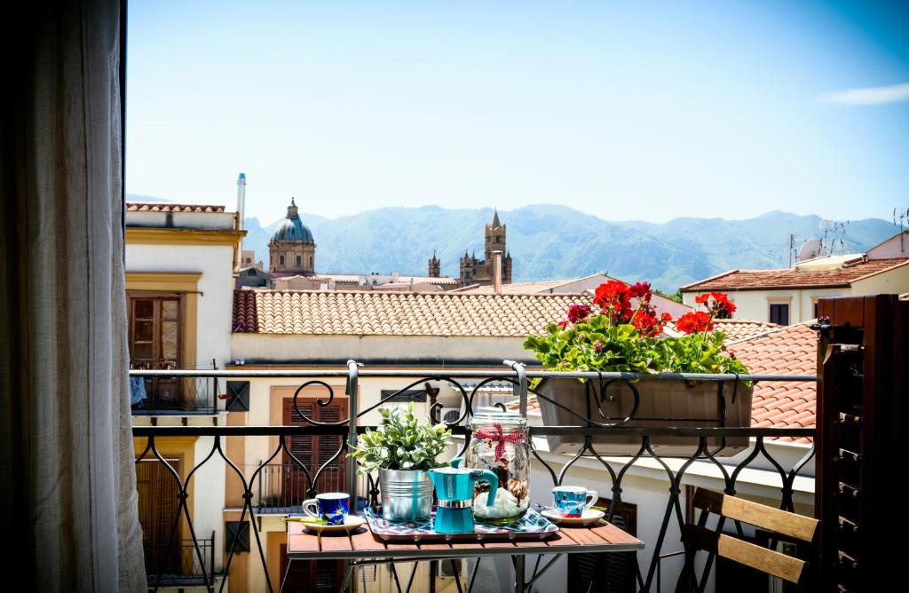 - un balcon avec une table et des fleurs dans l'établissement Capo House, à Palerme