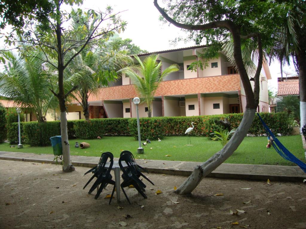 un bâtiment avec une cour plantée d'arbres et de balançoires dans l'établissement Hotel Pousada Paraíso das Águas, à Barreirinhas