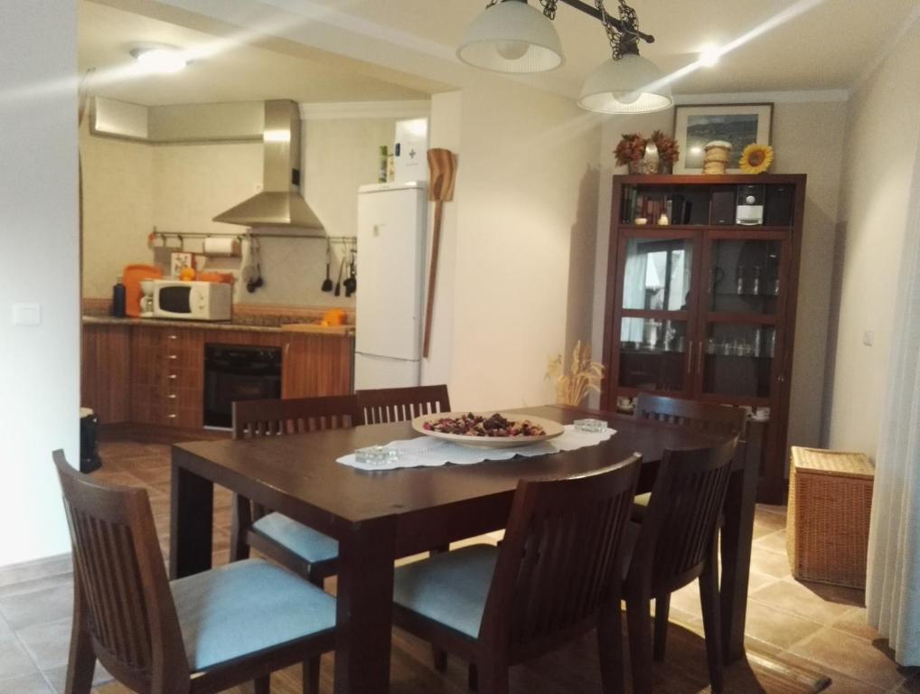 une cuisine avec une table en bois, des chaises et une assiette de nourriture dans l'établissement La Casa de Gonzala, à Belmonte
