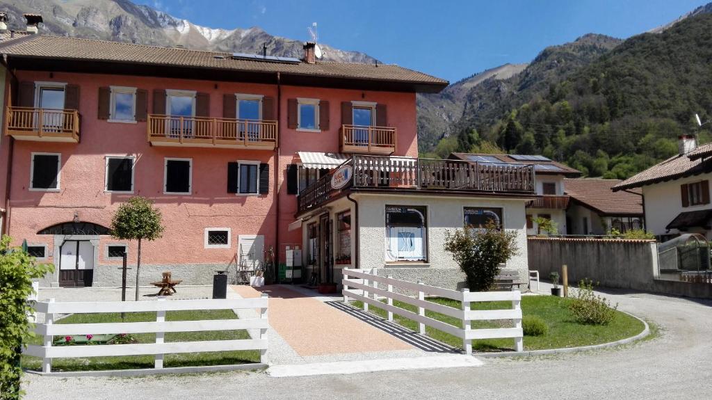 una casa con una recinzione bianca in un villaggio di Ledro Lake Suites a Ledro