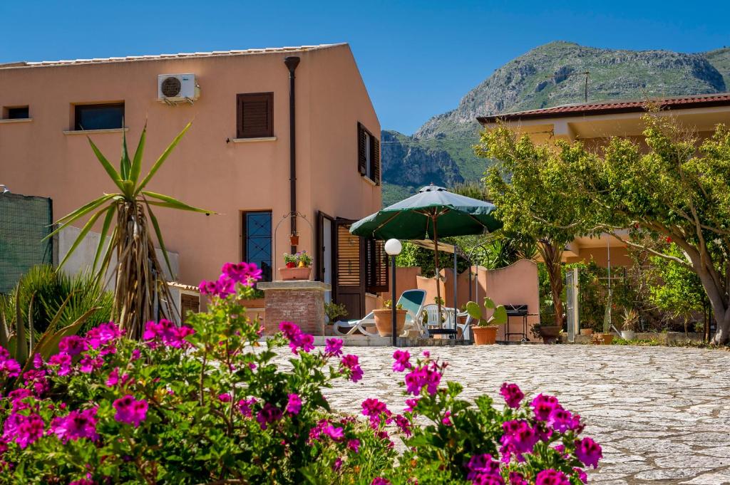 a house with flowers in front of it at Villa Oasi del Relax in Castellammare del Golfo