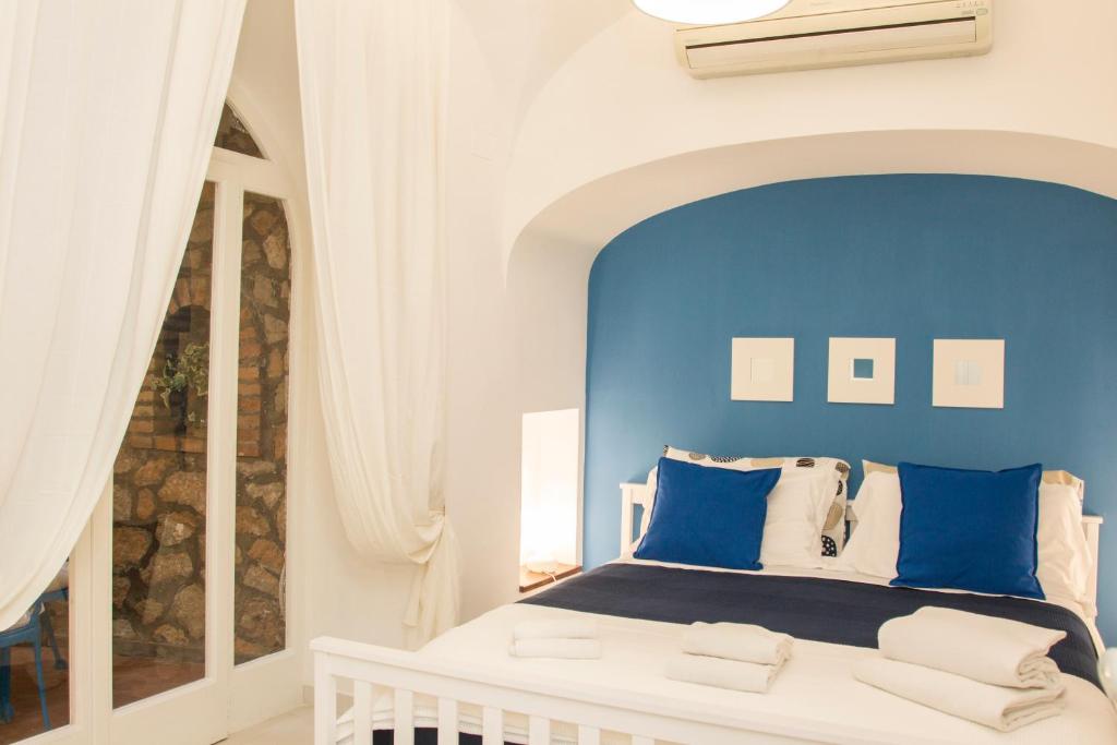 a bedroom with a blue wall and a white bed at Capri Blue in Capri