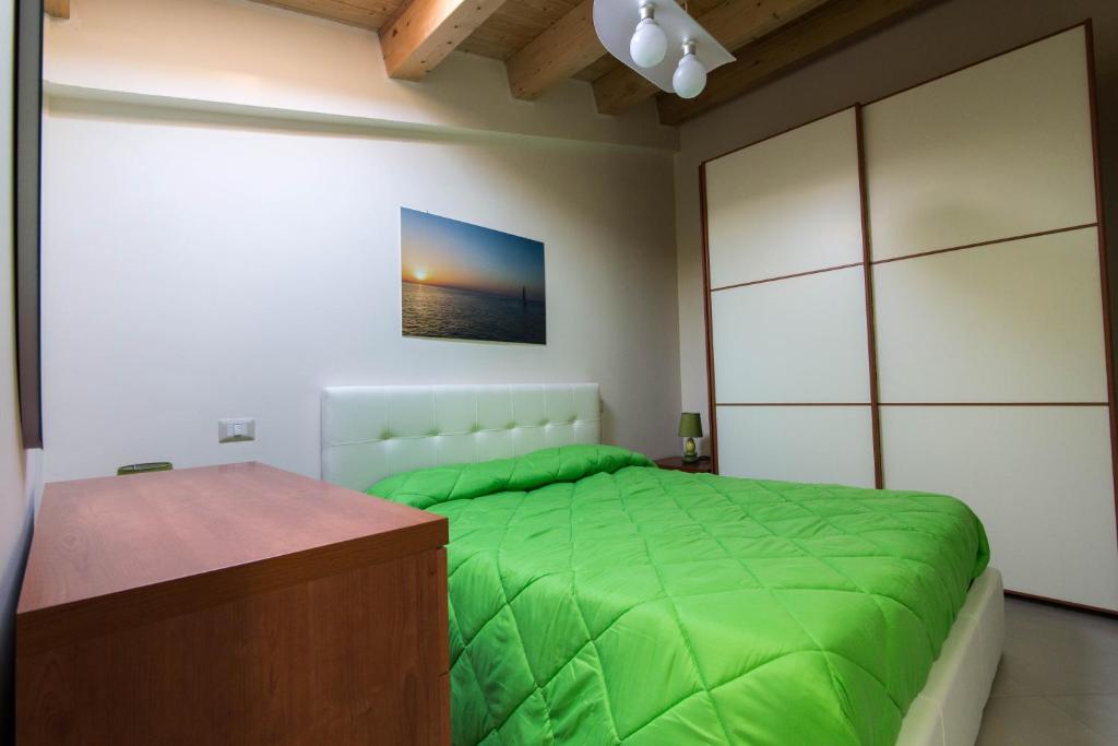1 dormitorio con cama verde y vestidor en Case Panoramiche sul Lago, en Messina