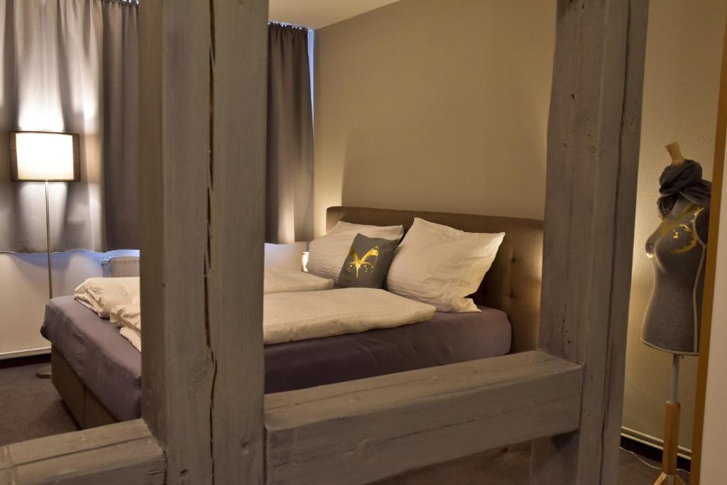 a small bedroom with a bed with a mirror at Herberge KAFFETIET in Wismar