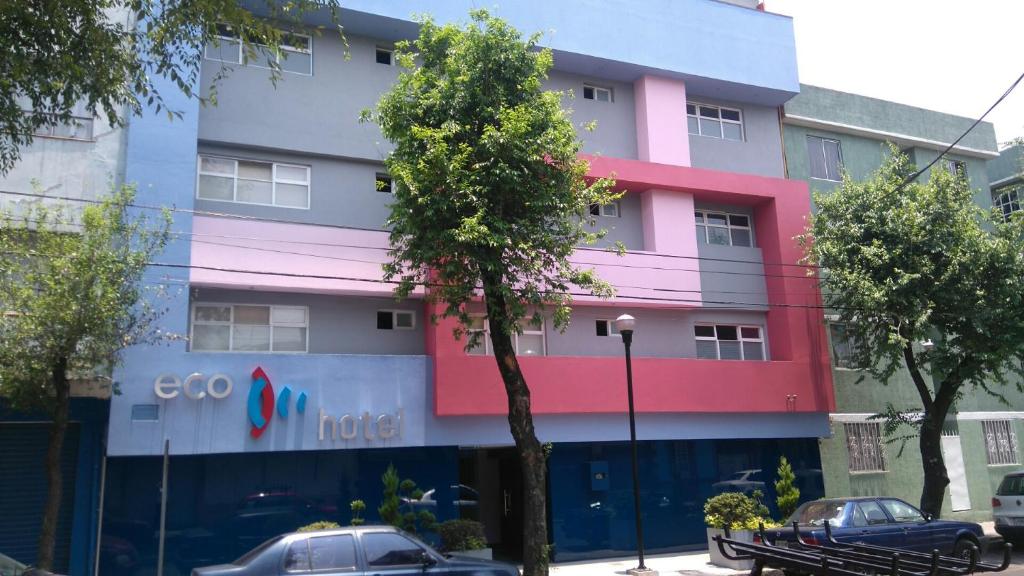 un edificio colorido con coches estacionados frente a él en Hotel H - Eco Adults Only, en Ciudad de México