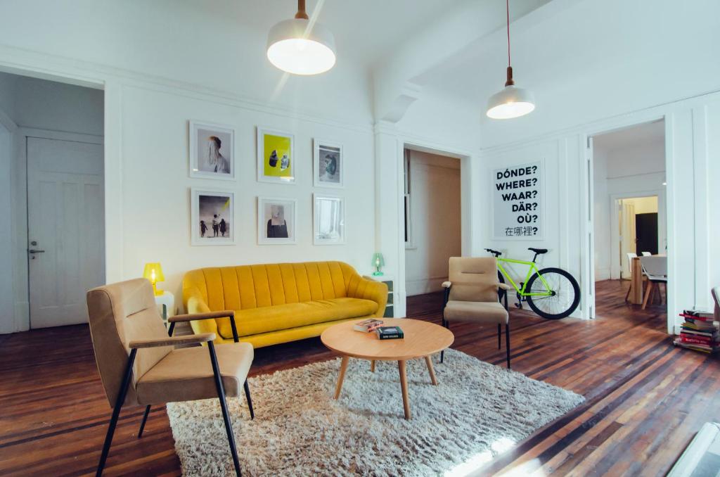 a living room with a yellow couch and chairs at NOT FOUND Hostel in Viña del Mar