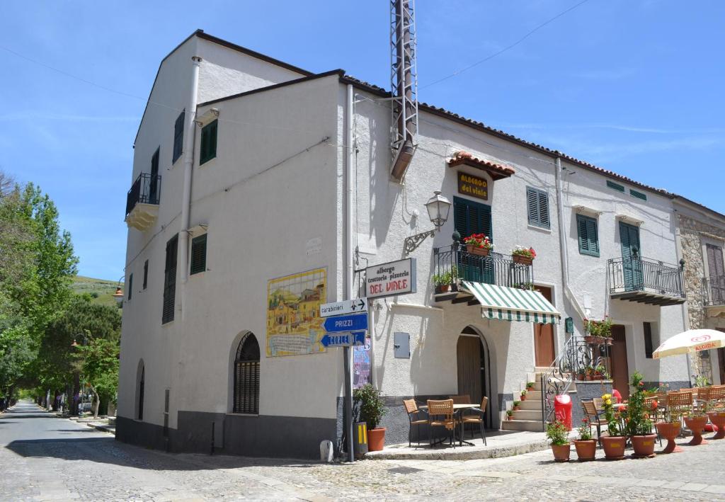 a white building on a street with flowers in pots at Albergo Ristorante Pizzeria Del Viale in Palazzo Adriano