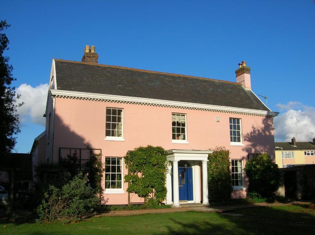 a large pink house with a black roof at Grange Farm House in Felixstowe