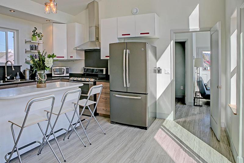 a kitchen with a stainless steel refrigerator and white cabinets at The Vue B&B in Seward