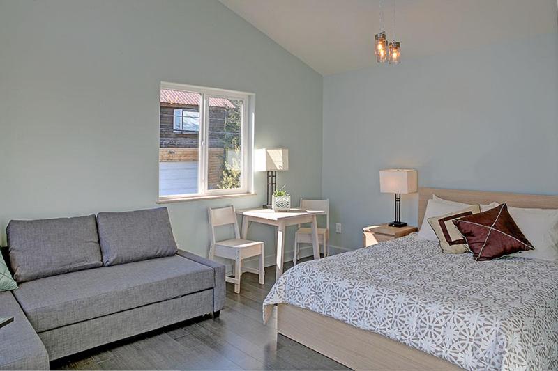 a bedroom with a bed and a couch and a window at The Vue B&B in Seward