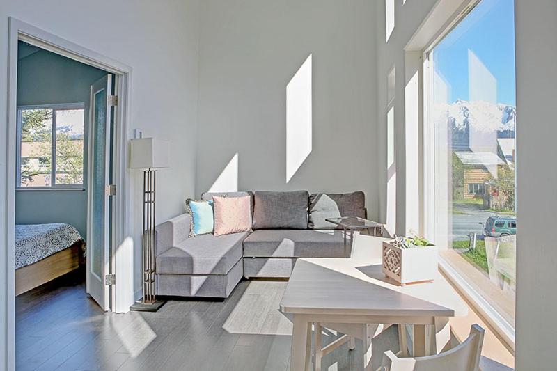 a living room with a couch and a large window at The Vue B&B in Seward