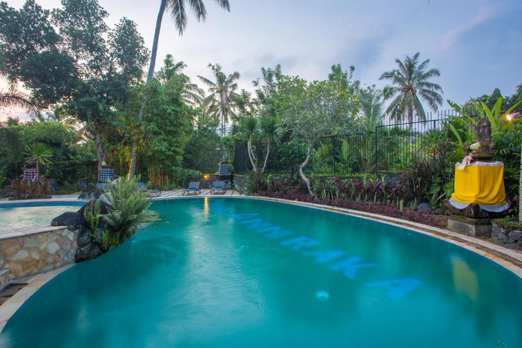 a swimming pool in a resort with blue water at Anini Raka Resort & Spa in Ubud