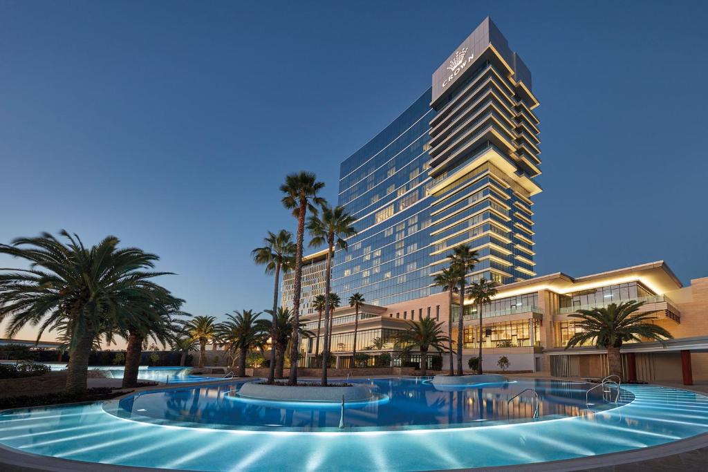 a hotel with palm trees and a large building at Crown Towers Perth in Perth