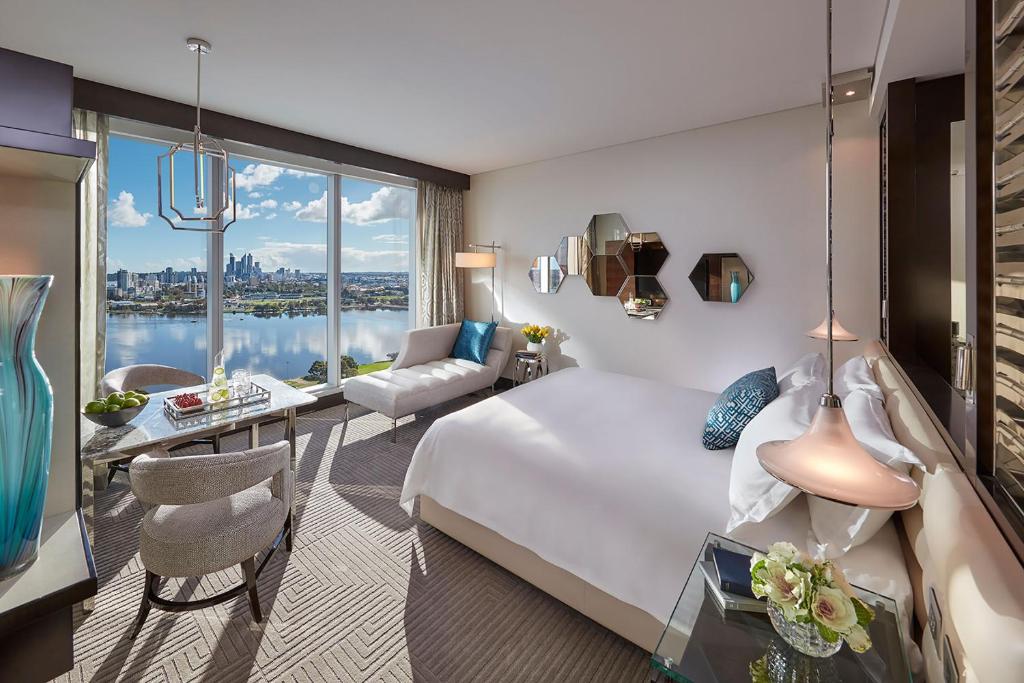 a hotel room with a large bed and a desk at Crown Towers Perth in Perth
