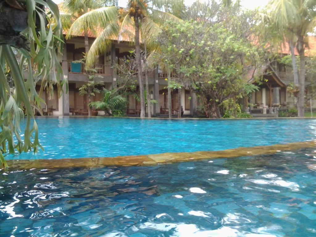 a swimming pool in front of a resort at Nirwana Sea Side Cottages in Lovina