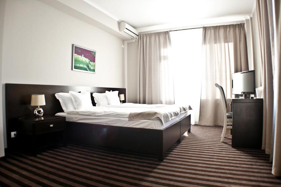 a hotel room with a bed and a window at Pensiunea Belanco in Arad