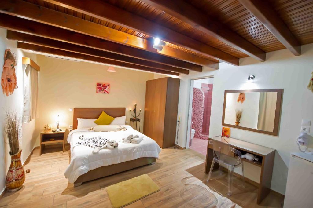 1 dormitorio con cama, escritorio y espejo en Asterolithos, en Fira