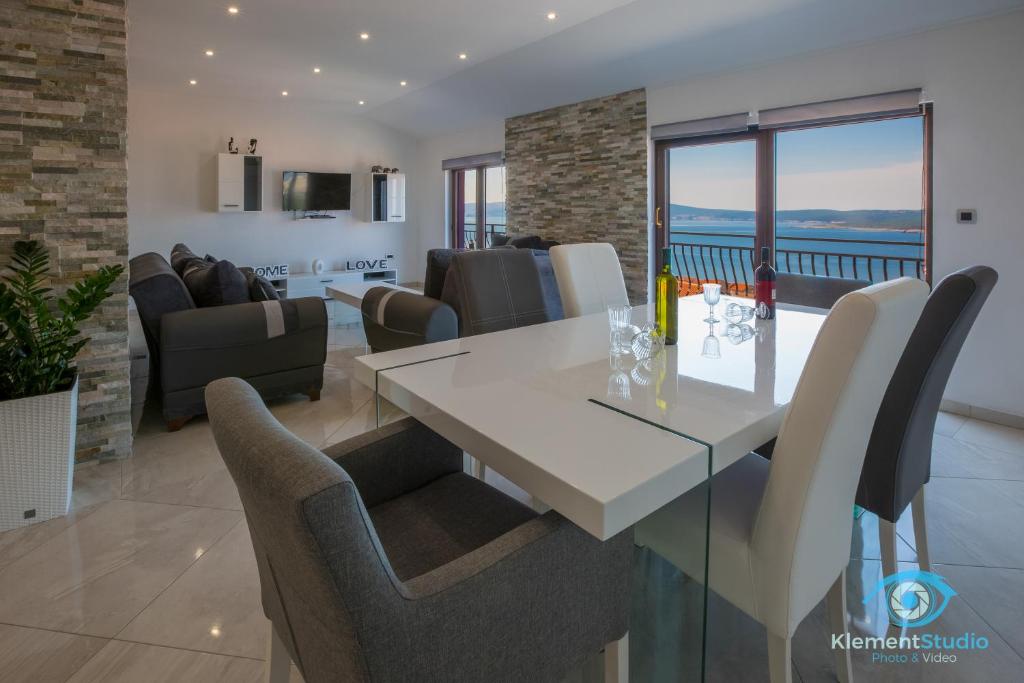 a dining room and living room with a table and chairs at Apartments Villa Lili in Crikvenica