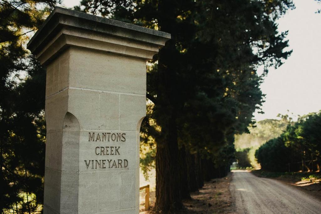 un pilar de piedra con las palabras que las naciones comprueban viñedo escrito en él en Quattro at Mantons Creek, en Red Hill South