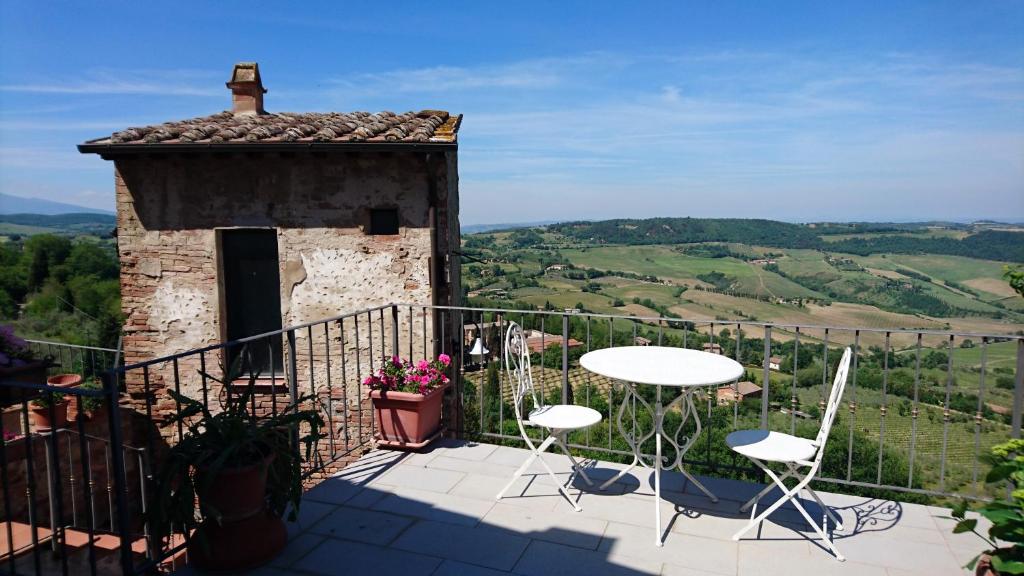 a balcony with tables and chairs on a building at Holiday House Montepulciano - Il Torrino in Montepulciano